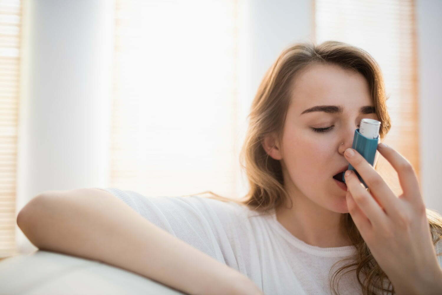 mujer utilizando un inhalador, asma