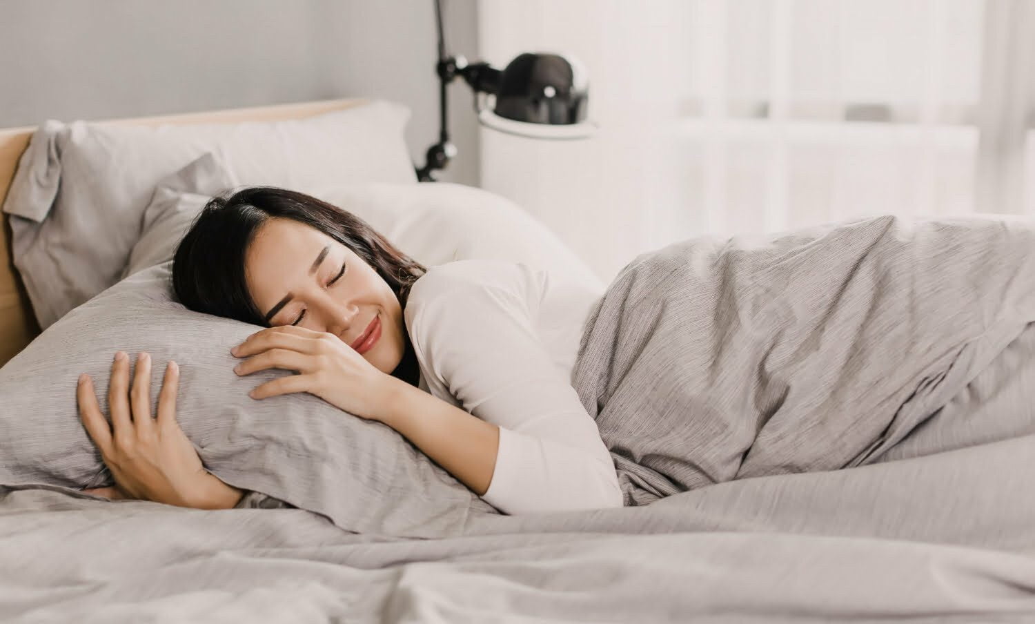 mujer durmiendo abrazada a la almohada