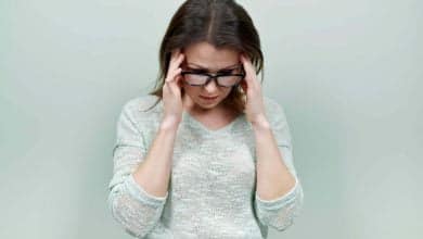 s&iacute;ntomas de la menoapusia mujer con lentes con dolor de cabeza