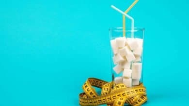 un vaso lleno de az&uacute;car con un cinta m&eacute;trica al rededor