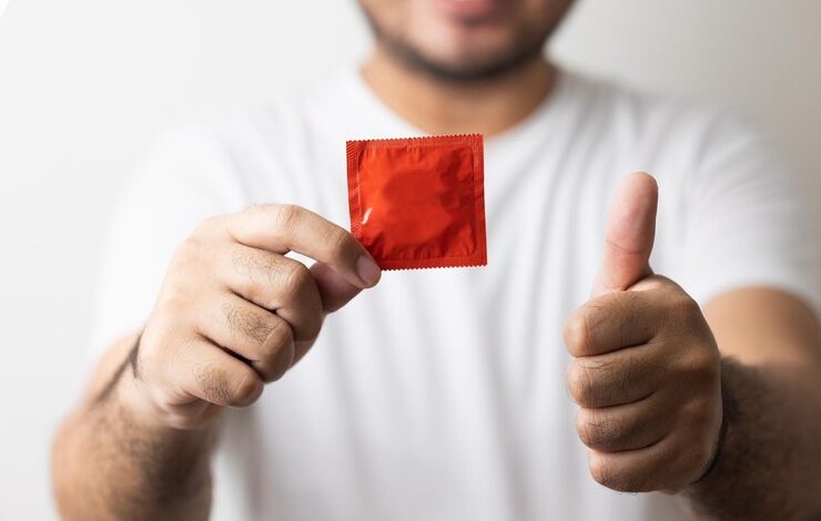El joven mostrando el condón a la cámara campaña para el sexo seguro y la anticoncepción cerrar preservativos preservativo