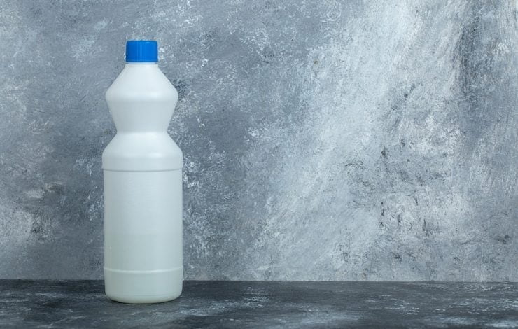 envase blanco de lej&iacute;a sobre m&aacute;rmol cloro