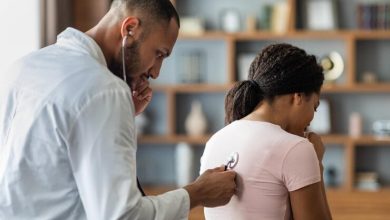 Hombre &aacute;rabe m&eacute;dico general revisando los pulmones de una mujer enferma con estetoscopio c&aacute;ncer