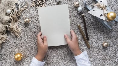 Foto las manos del ni&ntilde;o escriben una carta en una hoja de papel vac&iacute;a concepto de navidad y a&ntilde;o