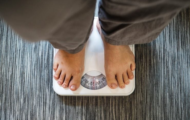 Mujer de pie en una escala perder peso dieta