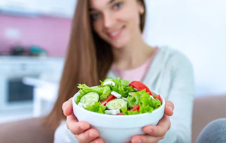 Foto mujer vegana saludable sosteniendo un plato de ensalada de verduras frescas. dieta orgánica