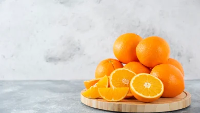 Una tabla de madera llena de jugosas rodajas de fruta naranja en la mesa de piedra vitamina C