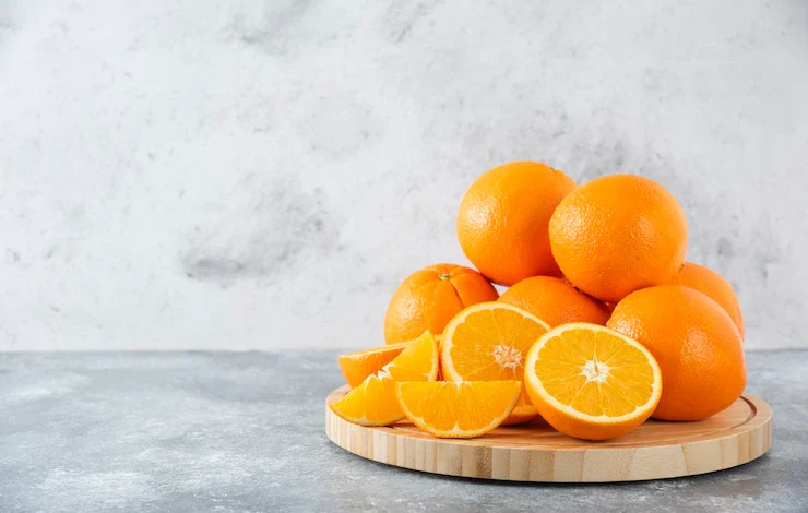 Una tabla de madera llena de jugosas rodajas de fruta naranja en la mesa de piedra vitamina C