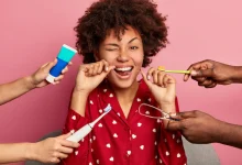 feliz joven rizada se cepilla los dientes con hilo dental, se preocupa por la higiene