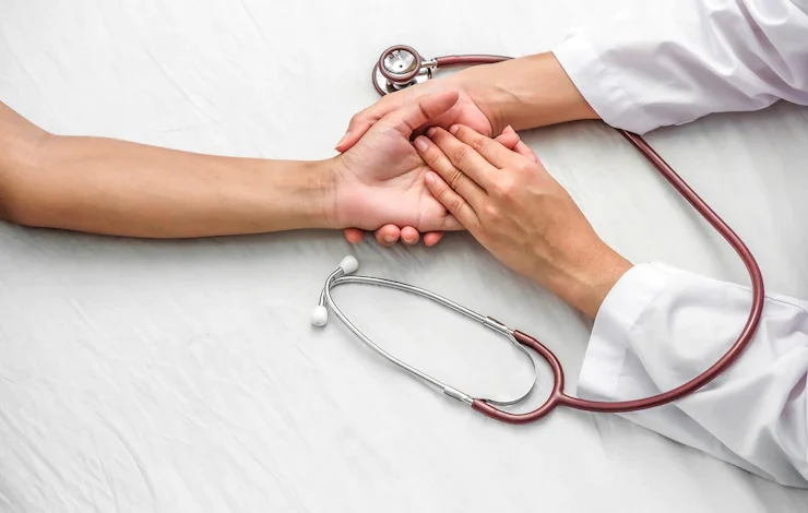 Mano del doctor que tranquiliza a su paciente femenino