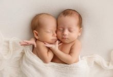 Pequeños gemelos recién nacidos en capullos blancos sobre un fondo blanco un gemelo recién