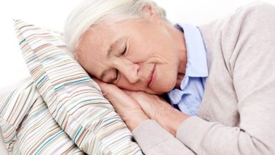 concepto de edad, relajaci&oacute;n y personas - anciana feliz durmiendo en una almohada en casa dormir