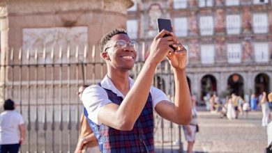 joven turista visitando la plaza mayor de madrid transmitiendo su viaje en su teléfono móvil