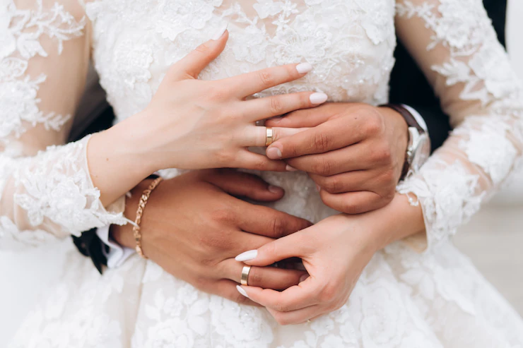 el novio y la novia se ponen los anillos de boda, vista frontal de las manos, boda