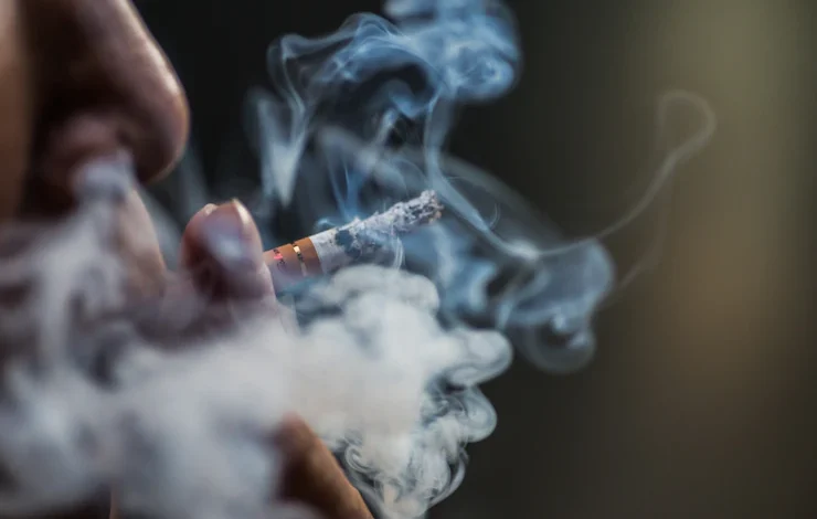 primer plano de una persona fumando un cigarrillo tabaco