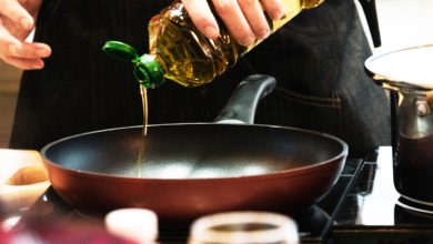 chef vertiendo aceite en una sart&eacute;n, chef cocinando comida en la cocina