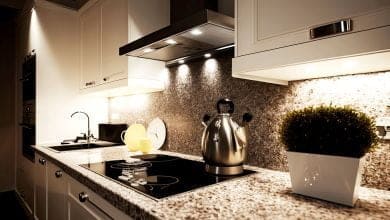 cocina moderna y elegante con encimera de granito y vitrocer&aacute;mica en tonos blancos interiore