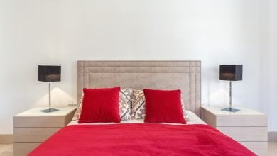 elegante dormitorio moderno con cama y almohadas rojas