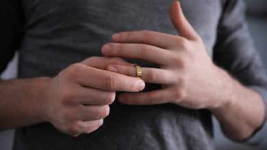 hombre quitándose el anillo de bodas en el concepto de divorcio de primer plano de fondo infieles