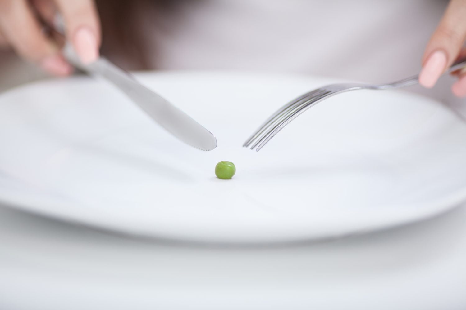 niña tratando de poner un guisante en el tenedor deficiencia de fósforo