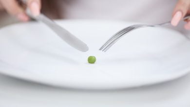 niña tratando de poner un guisante en el tenedor deficiencia de fósforo