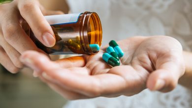 mano de mujer vierte las pastillas de la medicina fuera de la botella antibióticos