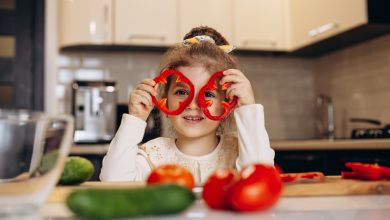 niña linda preparando ensalada de pimiento fresco verdura