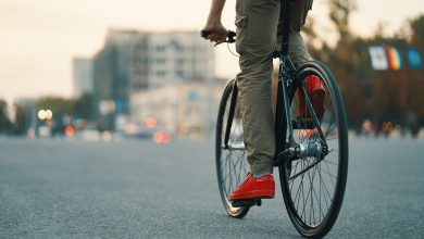 primer plano de las piernas del hombre casual en bicicleta clásica en la carretera