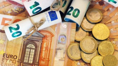 euromillones vista de ángulo alto de algunos billetes y monedas enrolladas en más billetes